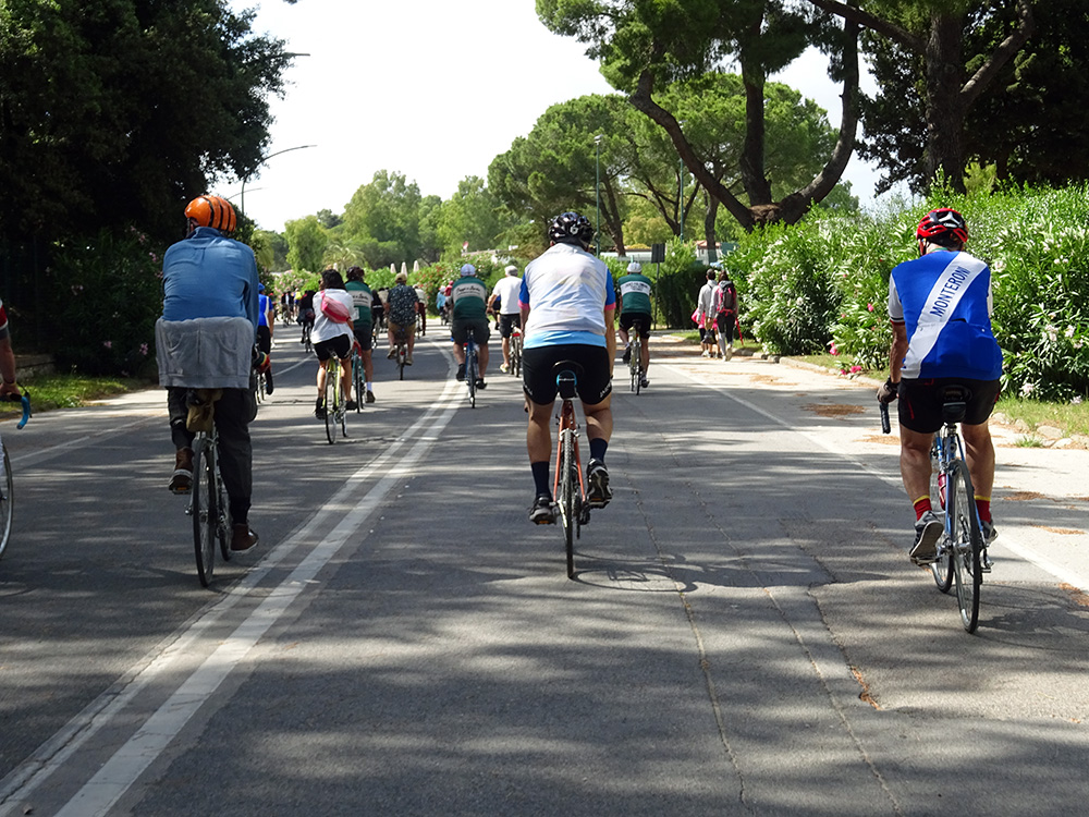 Ciclisti di spalle sul lungomare di Follonica pedalare nel golfo del sole